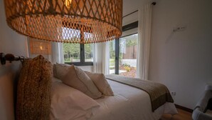 Une chambre à coucher avec un lit, une fenêtre et une lampe en osier.