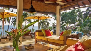 A sunlit lounge area with a sofa, a coffee table, and a plant. - Saffron House: Private Seafront Villa with Infinity Pool & Tropical Gardens (Dikwella)
