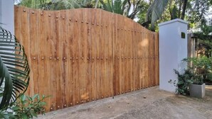 A wooden gate with rivets, a concrete pathway, and a potted plant. - Saffron House: Private Seafront Villa with Infinity Pool & Tropical Gardens (Dikwella)