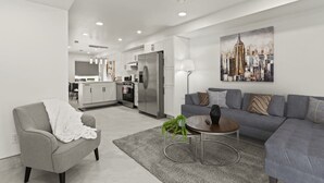A modern living room with a grey sofa, a coffee table, and a painting of a cityscape. - Luxury Side by Side Lakeview Condos (Leamington)