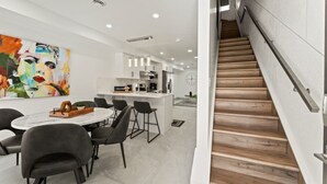 A modern kitchen with white cabinets, a central island, and pendant lighting. - Luxury Side by Side Lakeview Condos (Leamington)