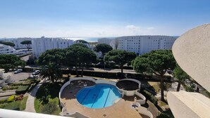 Zona residencial con piscina, árboles y vista al mar.