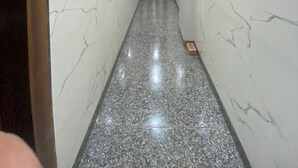 A hallway with marble walls and a polished floor, leading to a door at the end. - Hotel Air Admire - IGI Airport Delhi (New Delhi)