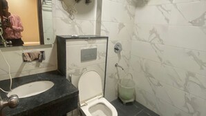 A bathroom with a toilet, sink, and hand dryer. - Hotel Air Admire - IGI Airport Delhi (New Delhi)