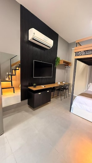 A modern hotel room with a TV, a bunk bed, a desk, and a chair. - Beach Flat Sonne (João Pessoa)