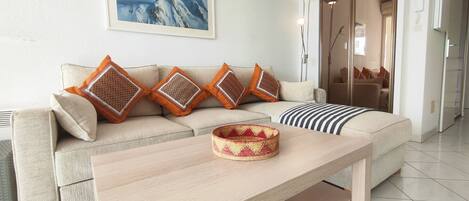 A living room with a sofa, a coffee table, and a framed picture on the wall.