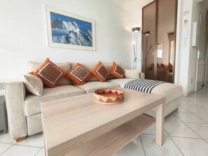 Un salon avec un canapé, une table basse et un tableau encadré au mur.