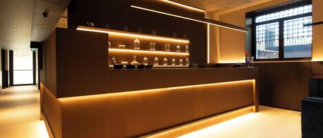 A modern reception desk with illuminated shelves, a large window, and a minimalist design.