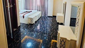 A hotel room with a bed, bedside table, and a mirror.