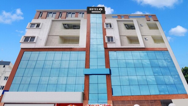Ein Hotel mit moderner Fassade, großen Fenstern und einem zentralen Eingang mit dekorativen Elementen.