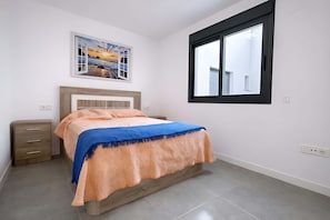 A bedroom with a bed, a nightstand, a window, and a wall-mounted picture. - Marinsa Beach - Penthouse (Torrox)