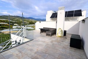 A rooftop terrace with solar panels, a staircase, and a view of the countryside. - Marinsa Beach - Penthouse (Torrox)