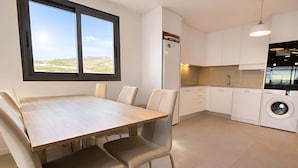 A modern kitchen with white cabinets, a built-in oven, and a washing machine. - Marinsa Beach - Penthouse (Torrox)