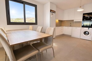 A modern kitchen with white cabinets, a built-in oven, and a washing machine. - Marinsa Beach - Penthouse (Torrox)