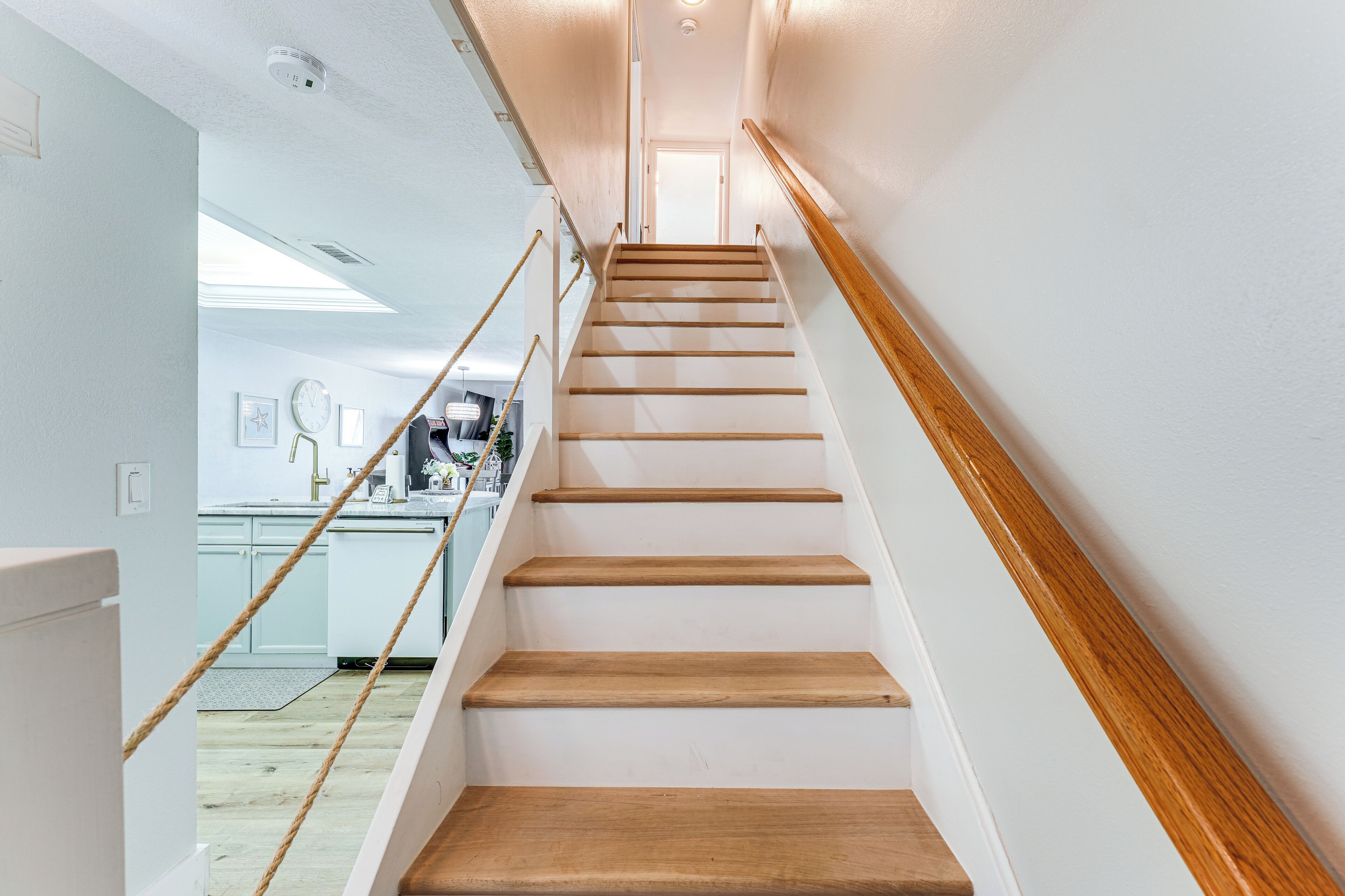 Eine Treppe mit Holzstufen und Geländer, die zu einer Tür oben führt.