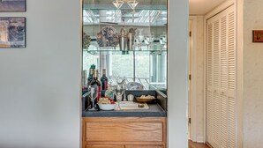 A kitchen with a glass partition, wooden cabinets, a sink, and various kitchen items. - Enjoy Coastal Living! Condo on Kiawah Island (Kiawah Island)