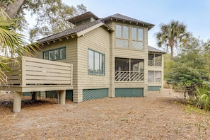 Une maison à deux étages avec un balcon, un garage et une cour clôturée.