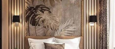 Quarto moderno com cama grande, painéis decorativos na parede e iluminação ambiente.