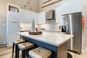 A modern kitchen with a large island, stainless steel appliances, and bar stools. - 3 Mi to Keystone Resort: Updated Condo w/ Balcony! (Keystone)