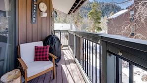 Eine Holzterrasse mit einer Bank, einer Uhr und einem Willkommensschild.