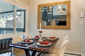 A dining table set with plates, cutlery, and a candle, with a large ornate mirror above it. - 3 Mi to Keystone Resort: Updated Condo w/ Balcony! (Keystone)