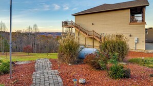 A two-story house with a wooden deck and a staircase leading to a balcony. - Byrdstown Apartment < 4 Mi to Dale Hollow Lake! (Byrdstown)