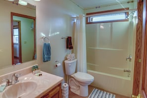 A bathroom with a sink, toilet, and shower.