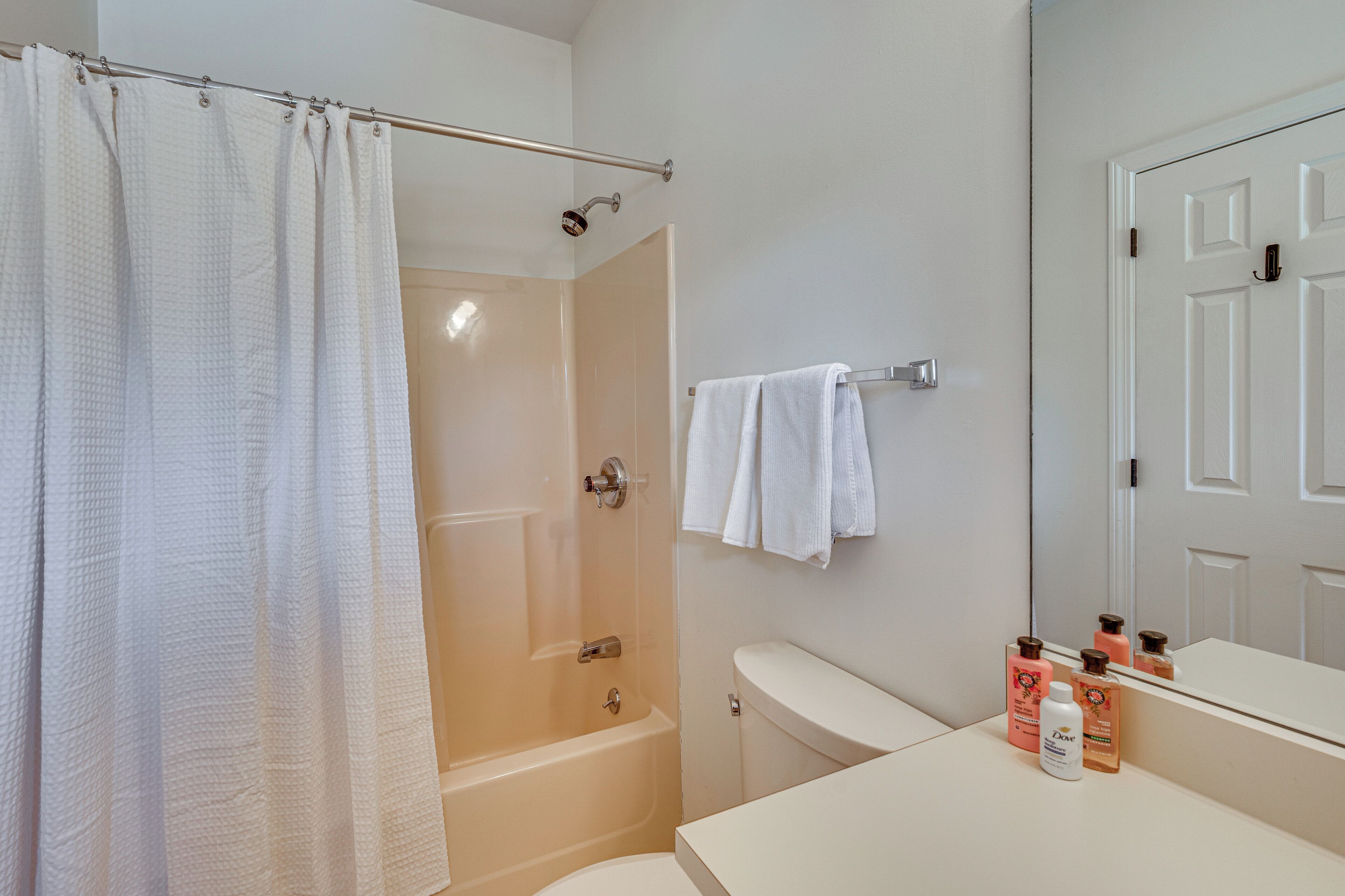 A bathroom with a bathtub, a toilet, a sink, and a shower curtain.
