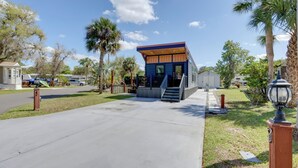 A modern building with a blue exterior, a wooden deck, and a staircase leading to the entrance.