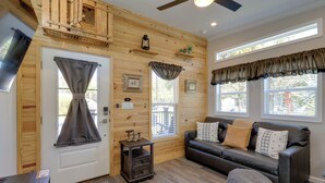 A cozy living room with a wooden wall, a leather sofa, and a small side table.