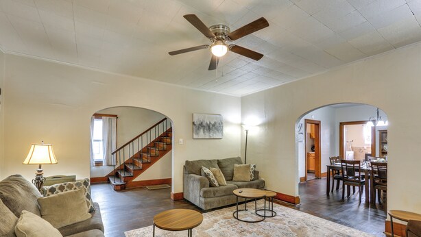 A spacious living room with a ceiling fan, a sofa set, a coffee table, and a dining area with chairs and a table. - Ohio Valley Home Near Franciscan University! (Steubenville)