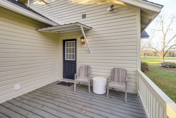 A porch with a door, two chairs, a small table, and a lantern. - 9 Mi to Georgia Southern University: Family Escape (Brooklet)