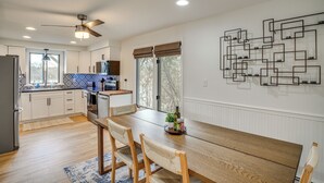 Una cocina moderna con armarios de madera, una mesa de comedor y un ventilador de techo.
