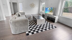 Una sala de estar moderna con sofá, mesa de centro y televisor.