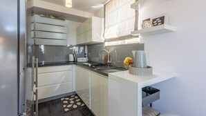 Eine moderne Küche mit weißen Schränken, einer schwarzen Arbeitsplatte und einem eingebauten Backofen.
