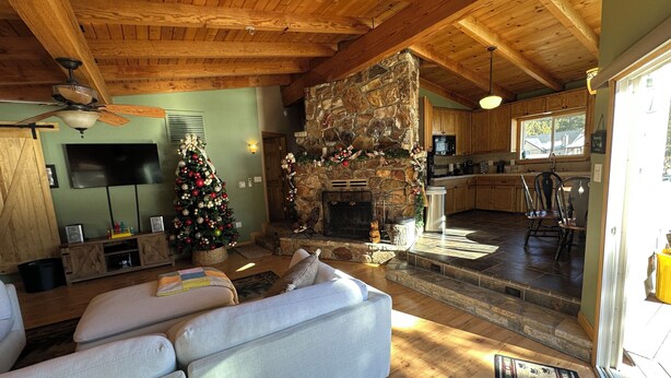 Un salon chaleureux avec une cheminée, un téléviseur et un sapin de Noël.
