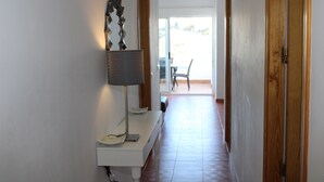 A hallway with a desk, lamp, and a door leading to a room. - 2 Bedroom Apartment (MOJACAR)