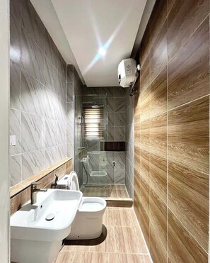 A modern bathroom with a freestanding bathtub, a sink, and a shower enclosure. - Dahila Apartment By Feenixkoncepts (Abuja)