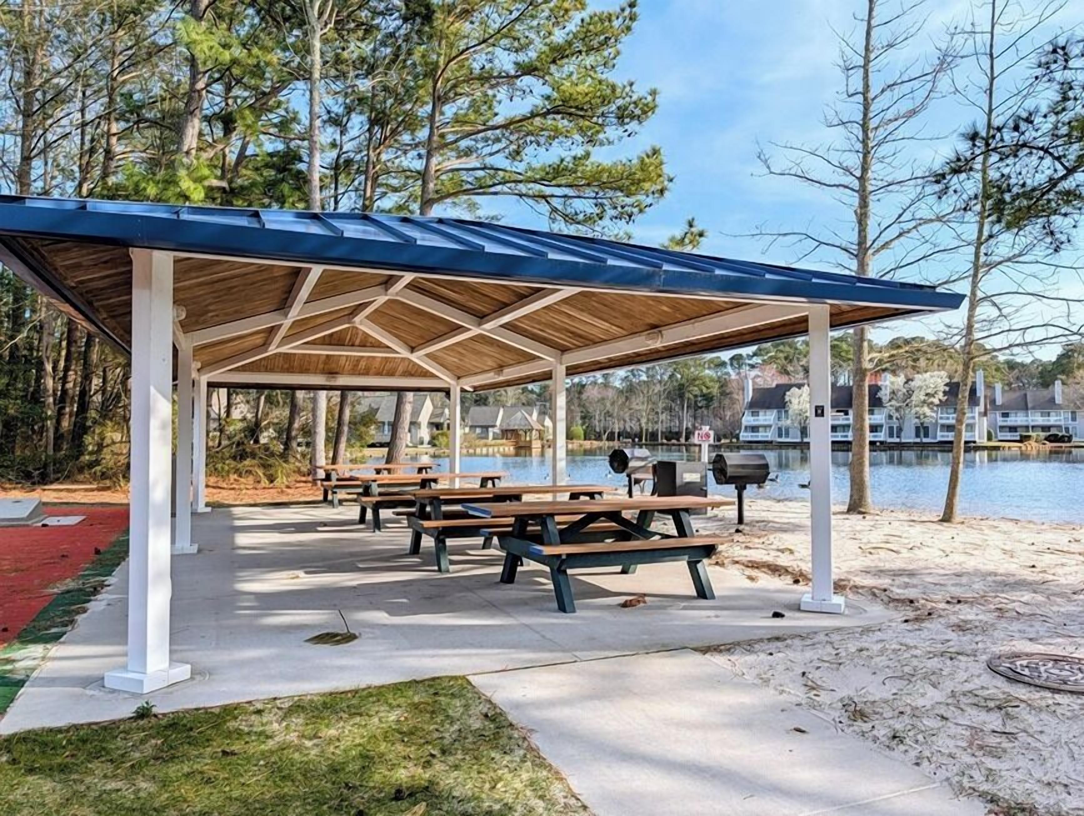 A covered picnic area with benches and grills.
