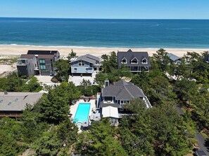 Eine Wohngegend an der Küste mit Häusern, einem Pool und Blick auf den Strand.