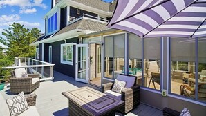 A modern house with a covered patio, outdoor furniture, and large windows. - 29532 N. Cotton Way - Cotton Patch East (Bethany Beach)