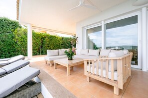 Ett modernt utomhusområde med en soffa, ett träbord och loungestolar.
