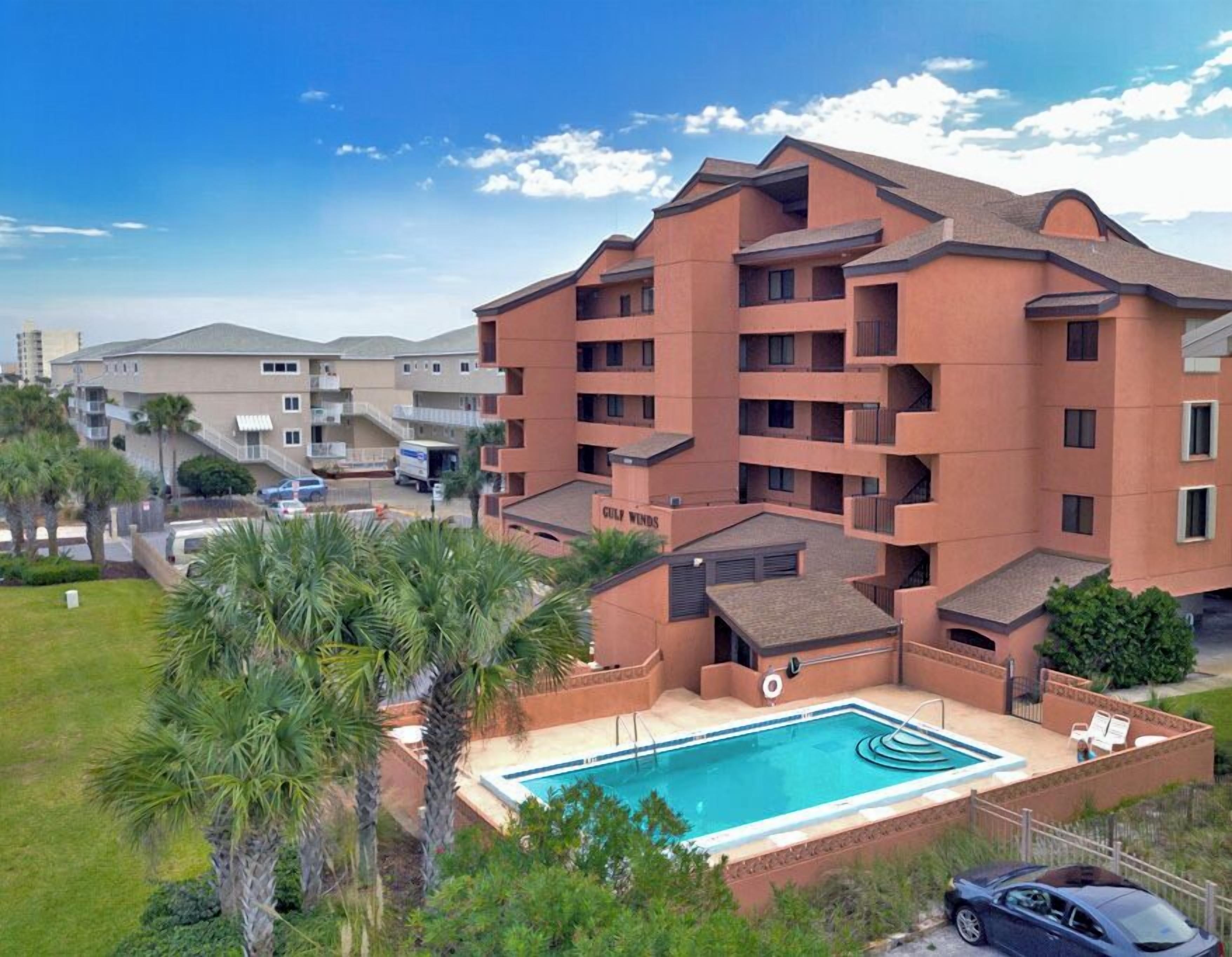 Ein mehrstöckiges Hotel mit Swimmingpool und Außenbereich.