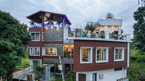 Une maison à plusieurs étages avec un balcon, un garage et un petit jardin.