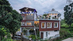 Une maison à plusieurs étages avec un balcon, un garage et un jardin.