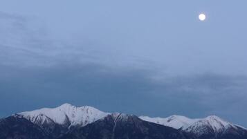 A mountain range with a visible moon in the sky.