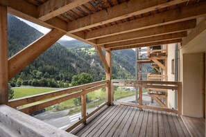 A wooden balcony with a view of a forested mountain landscape. - Chalet in Paradiski With Spa & Stunning Views (Peisey-Nancroix)