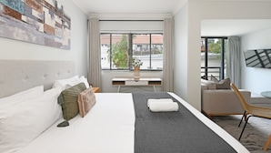 Ein Hotelzimmer mit Bett, Schreibtisch, Stuhl und Fernseher.