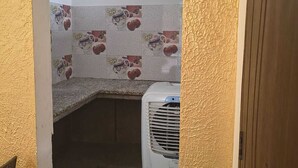 A room with a tiled backsplash, a white air conditioning unit, and a wooden door frame. - Hotel The Rudram Aura  (Rishikesh)