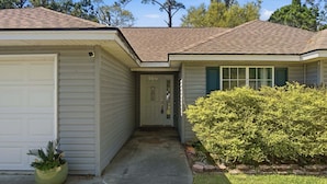 A residential house with a garage, a front door, and a well-maintained lawn. - 3br Savannah Home Sleeps 5 Near Historic District 3 Bedroom Home (Savannah)